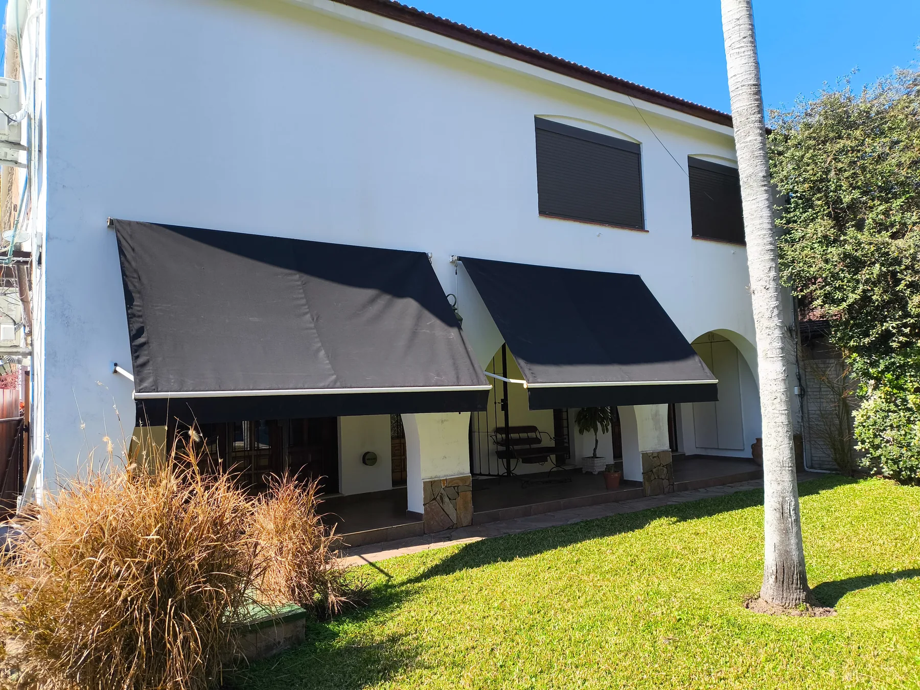 Toldo punto recto con tensión instalado en una casa